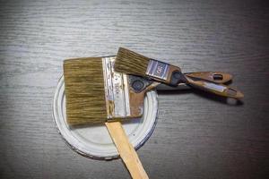 dois pincéis usados sujos em fundo de madeira foto