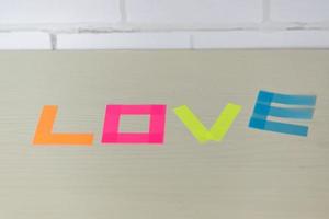 palavra amor feito de marcadores coloridos na mesa de madeira foto
