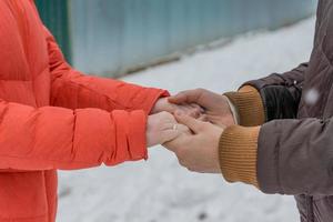 homem e mulher de mãos dadas. jovem casal caminhando em winter park foto