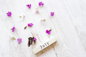 primeiro dia de julho, fundo colorido com calendário, flores e borboleta foto