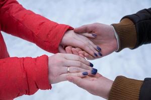 homem e mulher de mãos dadas. jovem casal caminhando em winter park foto