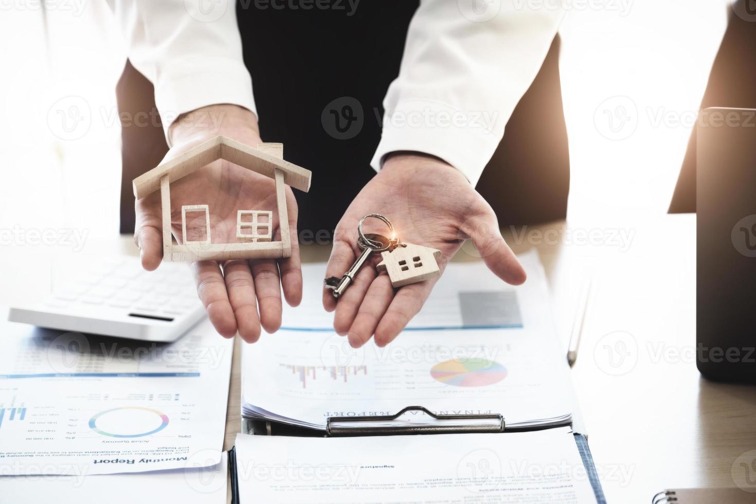 Immobilienmakler erklären sich damit einverstanden, ein Haus zu kaufen und den Kunden die Schlüssel in den Büros ihrer Agentur zu übergeben. Konzept Vereinbarung. foto