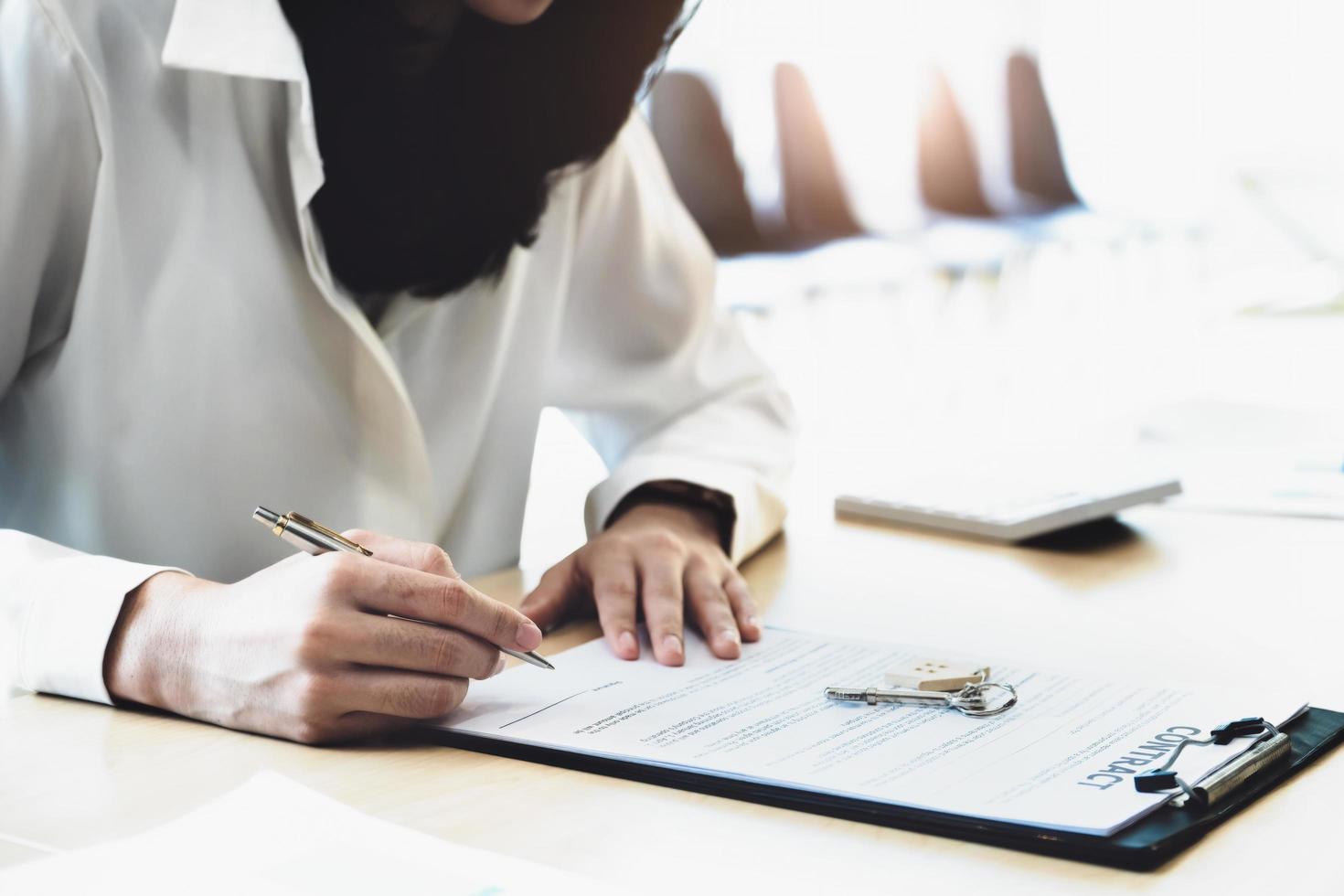 Der Kunde hält einen Stift in der Hand und liest den Wohnungskaufvertrag, bevor er ihn unterschreibt. foto