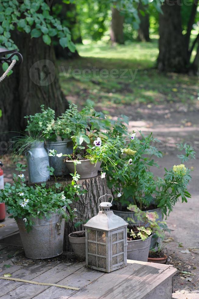 Garten Vintage Retro-Komposition mit Blumen und Kerzenlaterne. Hinterhofdekoration, Gartenarbeit und Hausdesign. vertikale Größe. foto