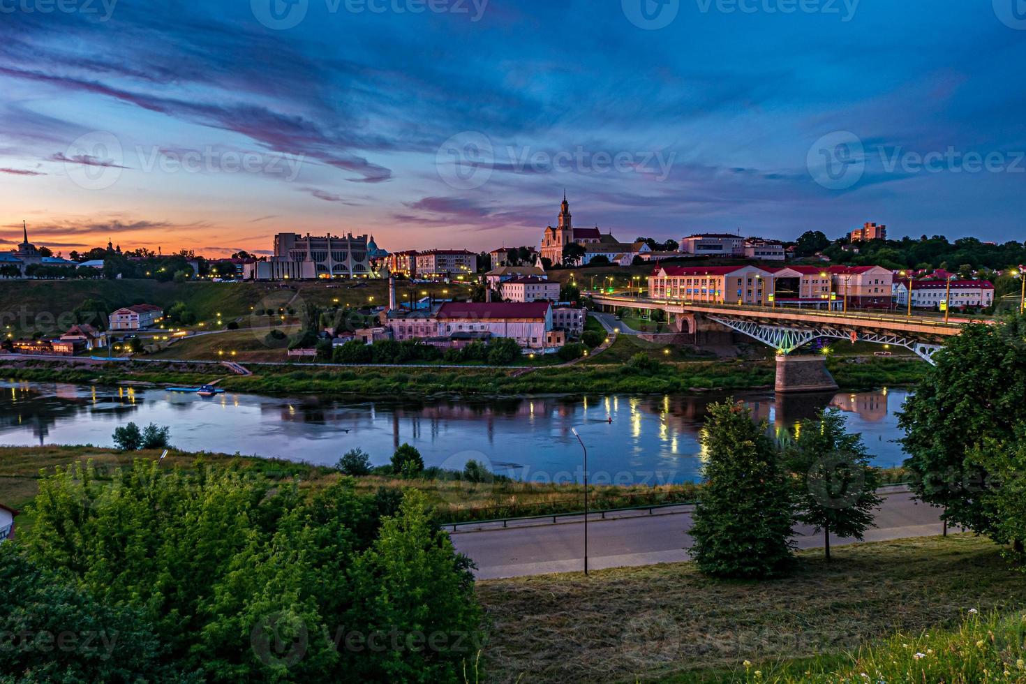 Panoramablick am Abend in der Altstadt am Ufer des breiten Flusses mit flauschigen, lockigen, rollenden Cirrostratus-Wolken und blauem, violettem, rotem Sonnenuntergangshimmel als Hintergrund foto