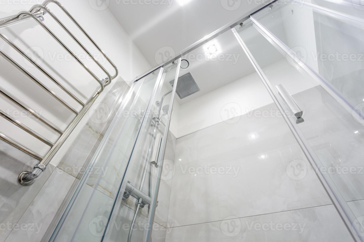 Details der Eckduschkabine mit wandmontierter Duschvorrichtung und Wasserhahnwaschbecken mit Wasserhahn im teuren Badezimmer foto
