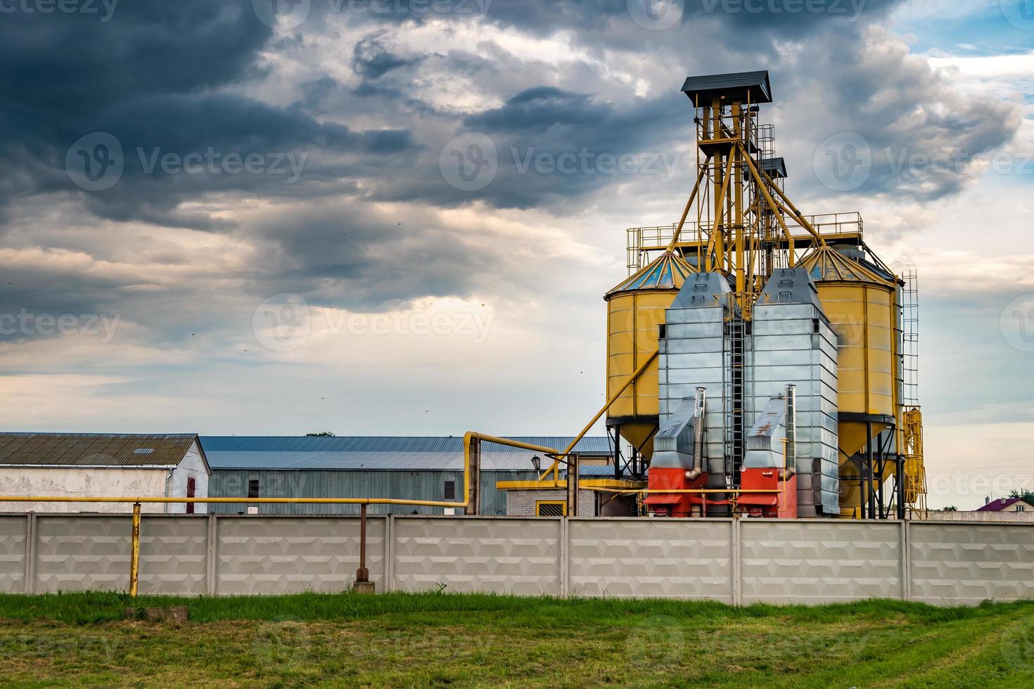 Agro-Verarbeitungsanlage zur Verarbeitung und Silos zum Trocknen, Reinigen und Lagern von landwirtschaftlichen Produkten, Mehl, Getreide und Getreide mit schönen Wolken foto