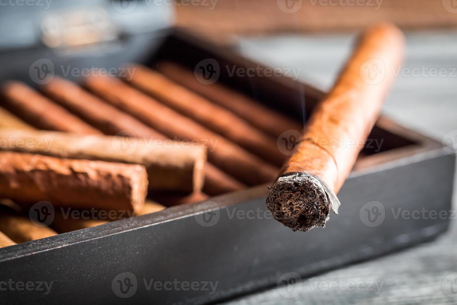 Nahaufnahme der brennenden Zigarre mit Rauch foto