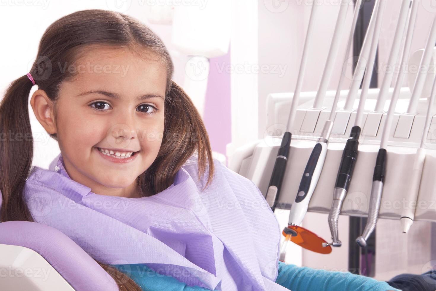hübsches kleines Mädchen im Zahnarztstuhl foto