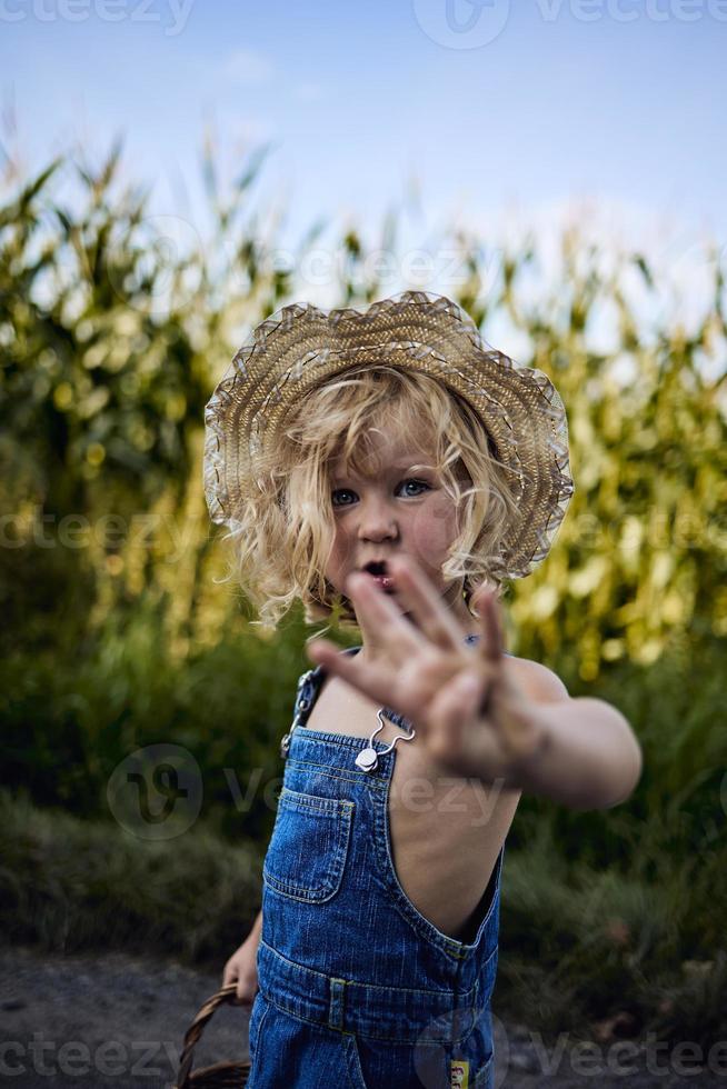 kleines blondes Mädchen, das auf dem Land spielt foto