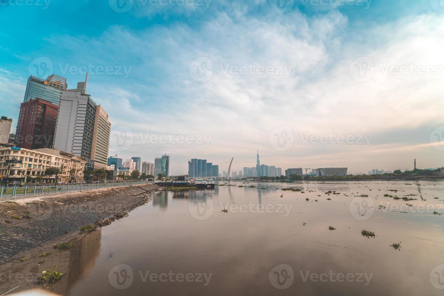 ho chi minh stadt, vietnam - 12. feb 2022 skyline mit wahrzeichen 81 wolkenkratzer, eine neue seilbrücke wird gebaut, die die halbinsel thu thiem und den bezirk 1 über den fluss saigon verbindet. foto