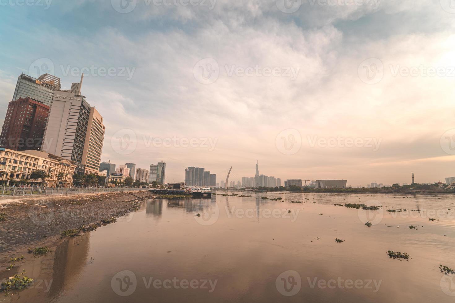 ho chi minh stadt, vietnam - 12. feb 2022 skyline mit wahrzeichen 81 wolkenkratzer, eine neue seilbrücke wird gebaut, die die halbinsel thu thiem und den bezirk 1 über den fluss saigon verbindet. foto