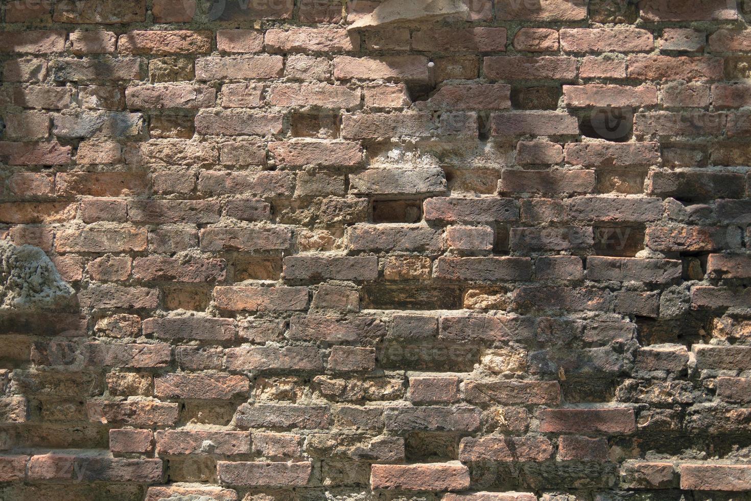 alte rote Backsteinmauer. textur des alten braunen und roten backsteinmauerhintergrundes. Fragment der Wand aus rotem Backstein in der Nähe. die Struktur des Hintergrunds. Vorlage für eine Inschrift. Modell für Designs. foto