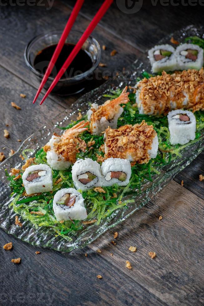 Sushi mit Thunfisch und Garnelen auf grünem Algensalatbett foto