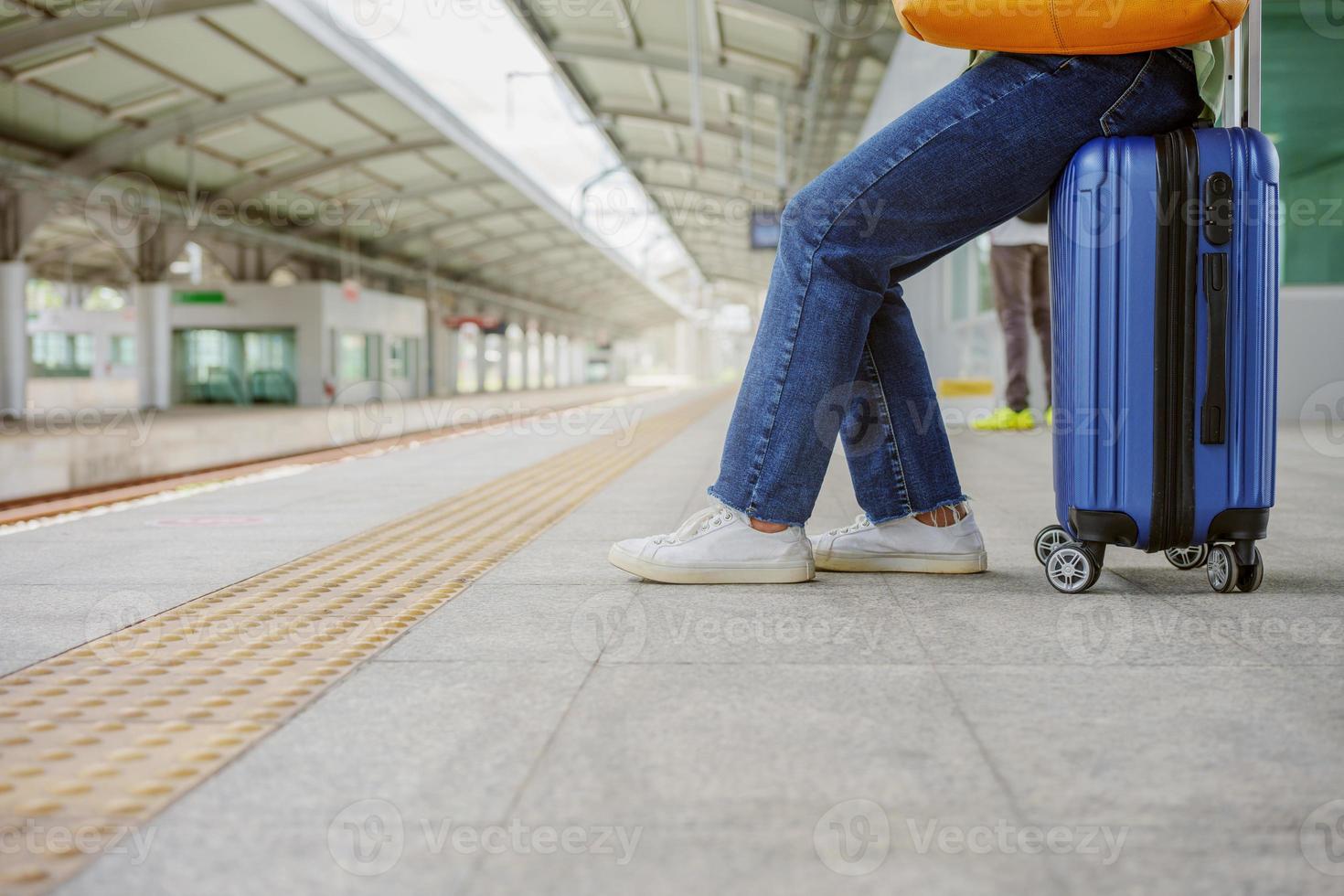 Frau, die auf der Tasche sitzt und am Bahnsteig in der Skytrain-Station wartet. foto