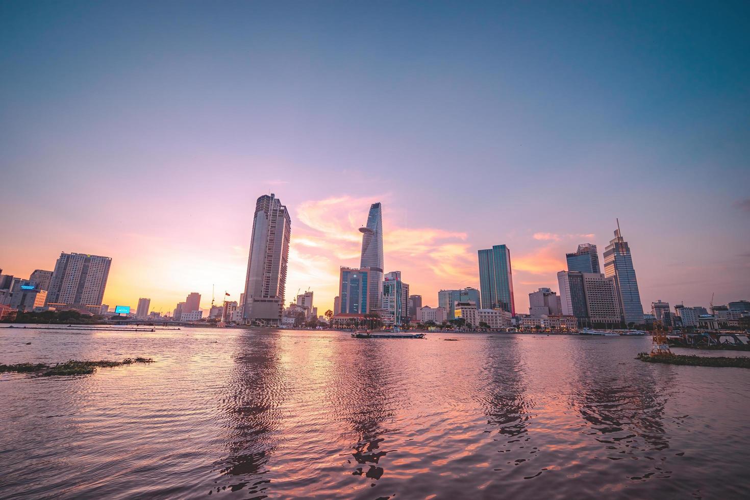 ho chi minh, vietnam - 13. feb 2022 blick auf bitexco financial tower building, gebäude, straßen, thu thiem bridge und saigon river in ho chi minh city bei sonnenuntergang. hochwertiges Panoramabild. foto