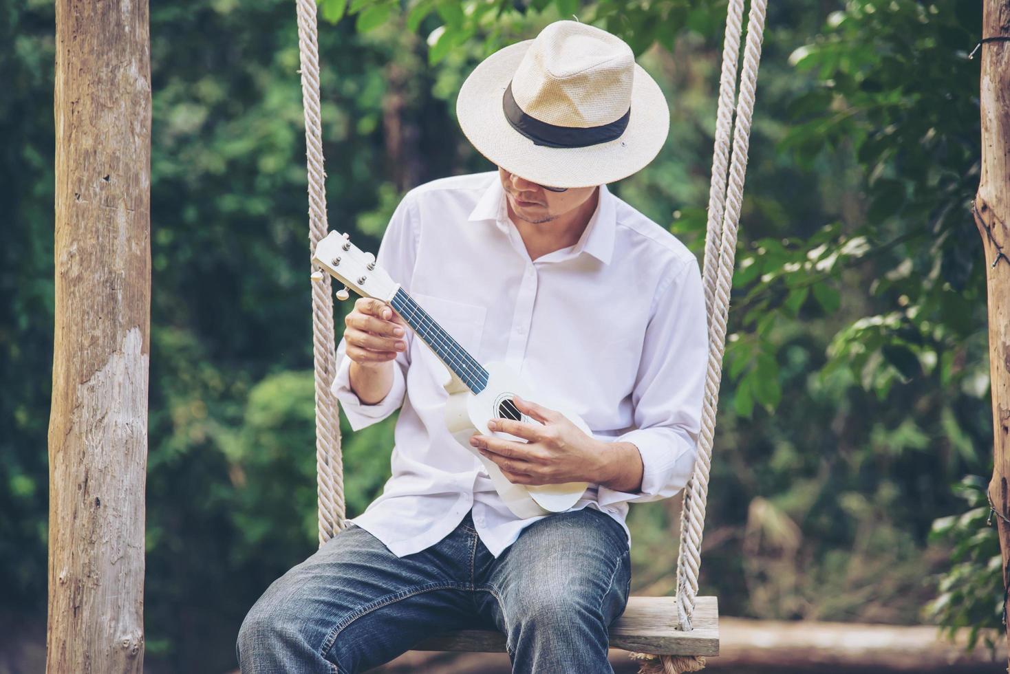 mann spielt ukulele neu im lebensstil der flussmenschen und musikinstrumente im naturkonzept foto