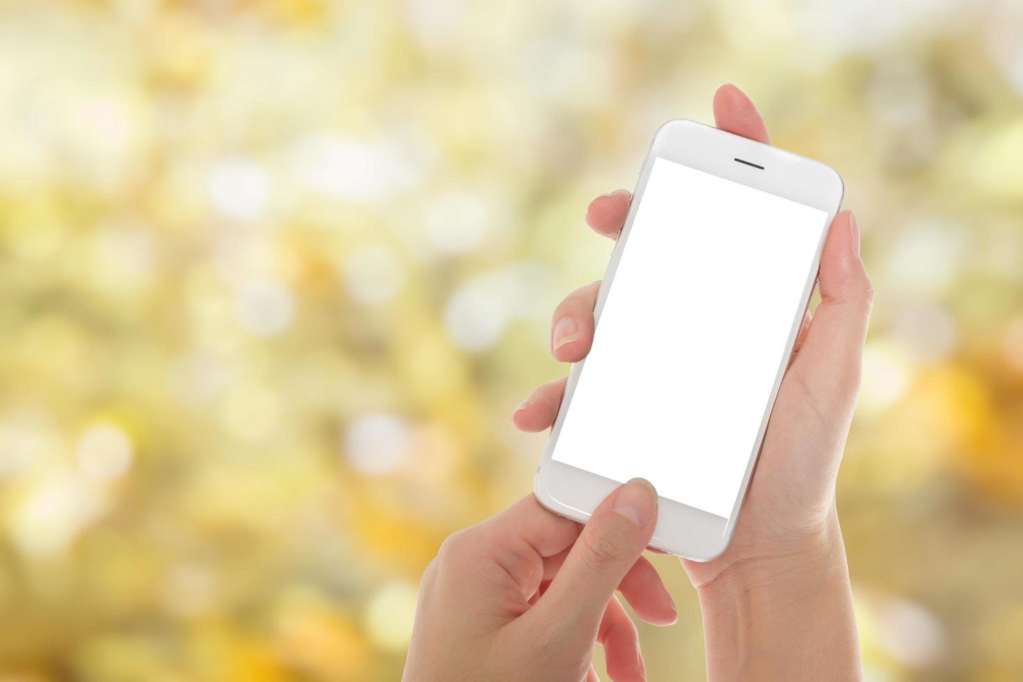Frauenhand zeigt Smartphone mit isolierten Bildschirmen mit abstraktem unscharfem goldenem Hintergrund foto