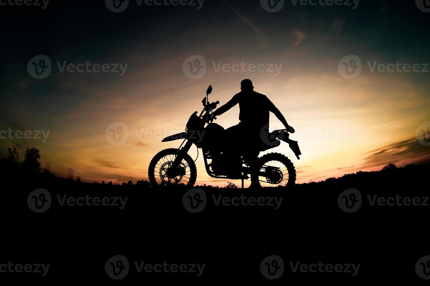 Herren-Silhouetten und Touren-Motocross-Bikes. Park zum Entspannen in den Bergen am Abend. abenteuerreise- und freizeitkonzept foto