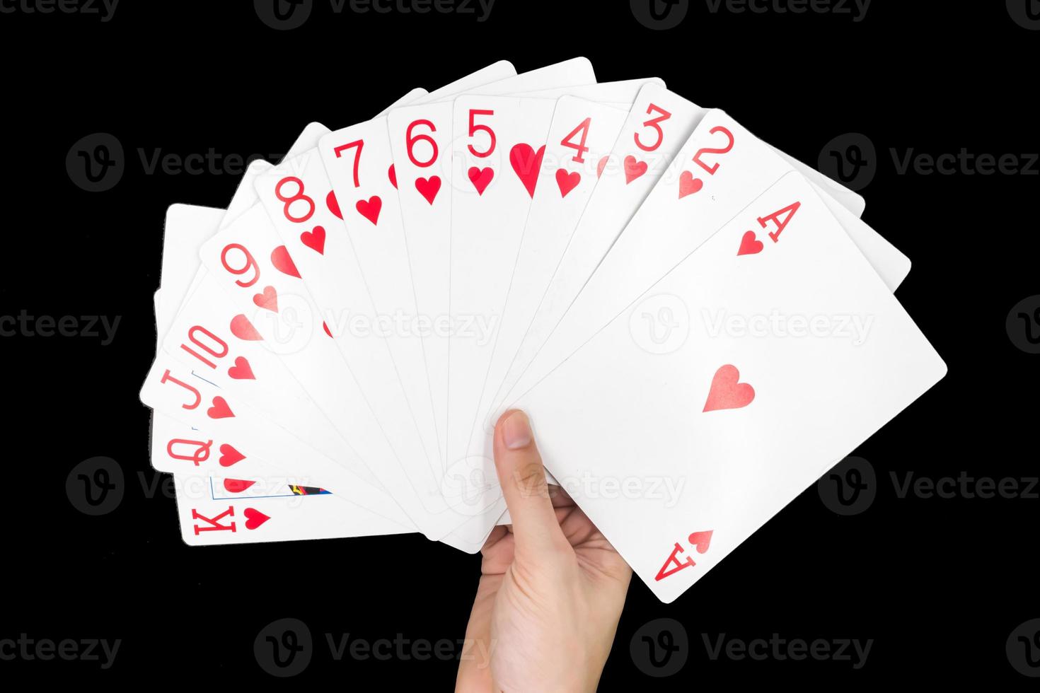 Hand, die Spielkarten auf schwarzem Hintergrund isoliert hält. foto