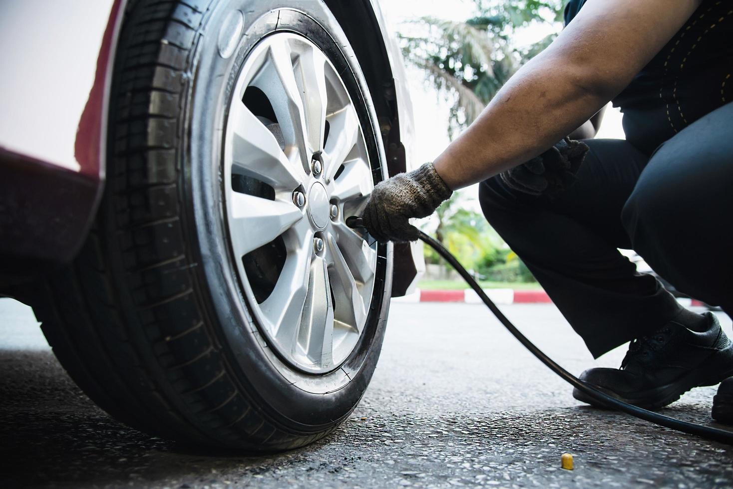 techniker pumpt autoreifen auf - autowartungsservice transportsicherheitskonzept foto