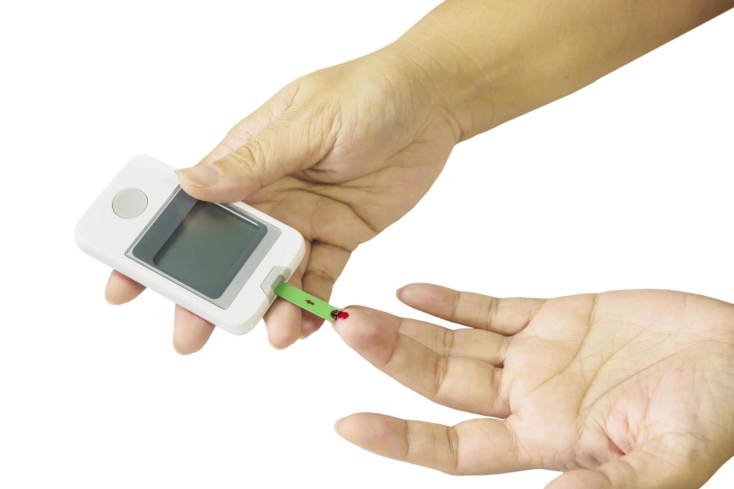 frau überprüft diabetes mit blutkontrollkit isoliert über weiß foto