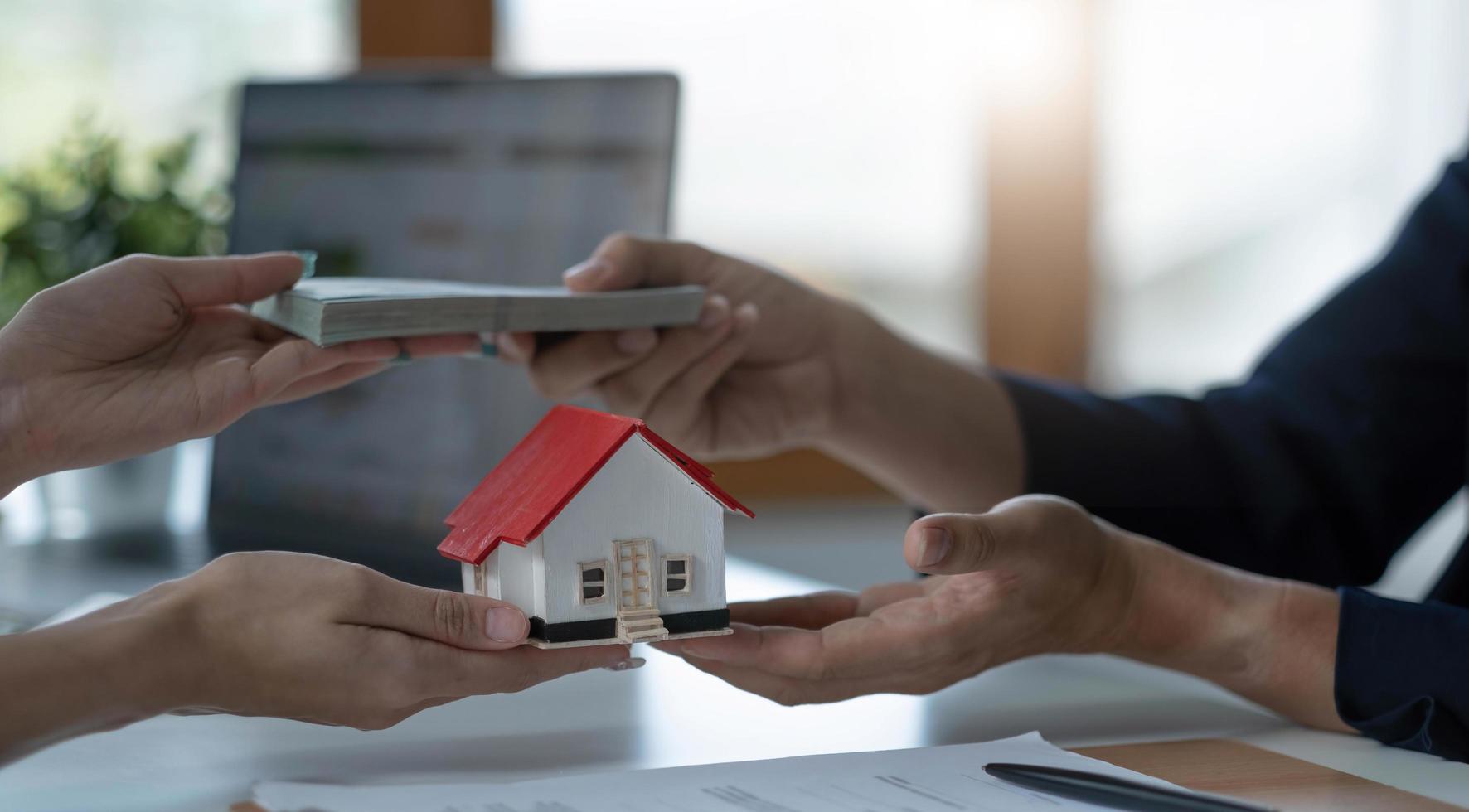 Eine professionelle Immobilienmaklerin erhält von ihrem Kunden eine Zahlung für ein Hausdarlehen oder eine Mietgebühr. Immobilieninvestitionskonzept. beschnittenes Bild foto