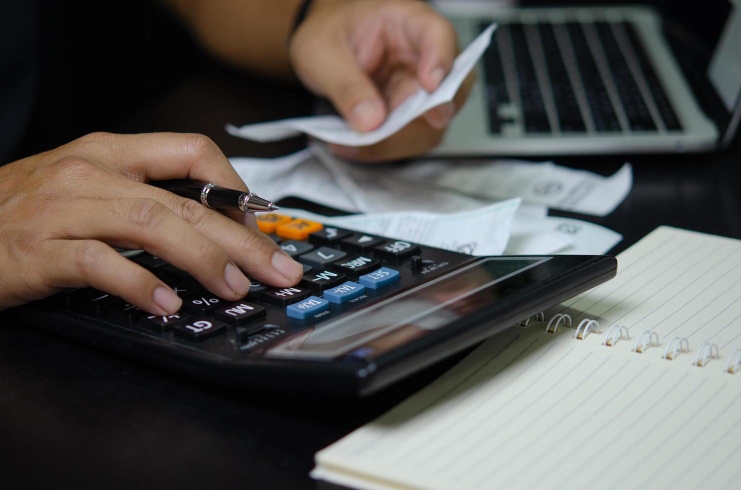 mannhand, die stift und rechnerrechnungen oder steuerbeleg hält. Geschäftsfinanzierungskonzept. foto