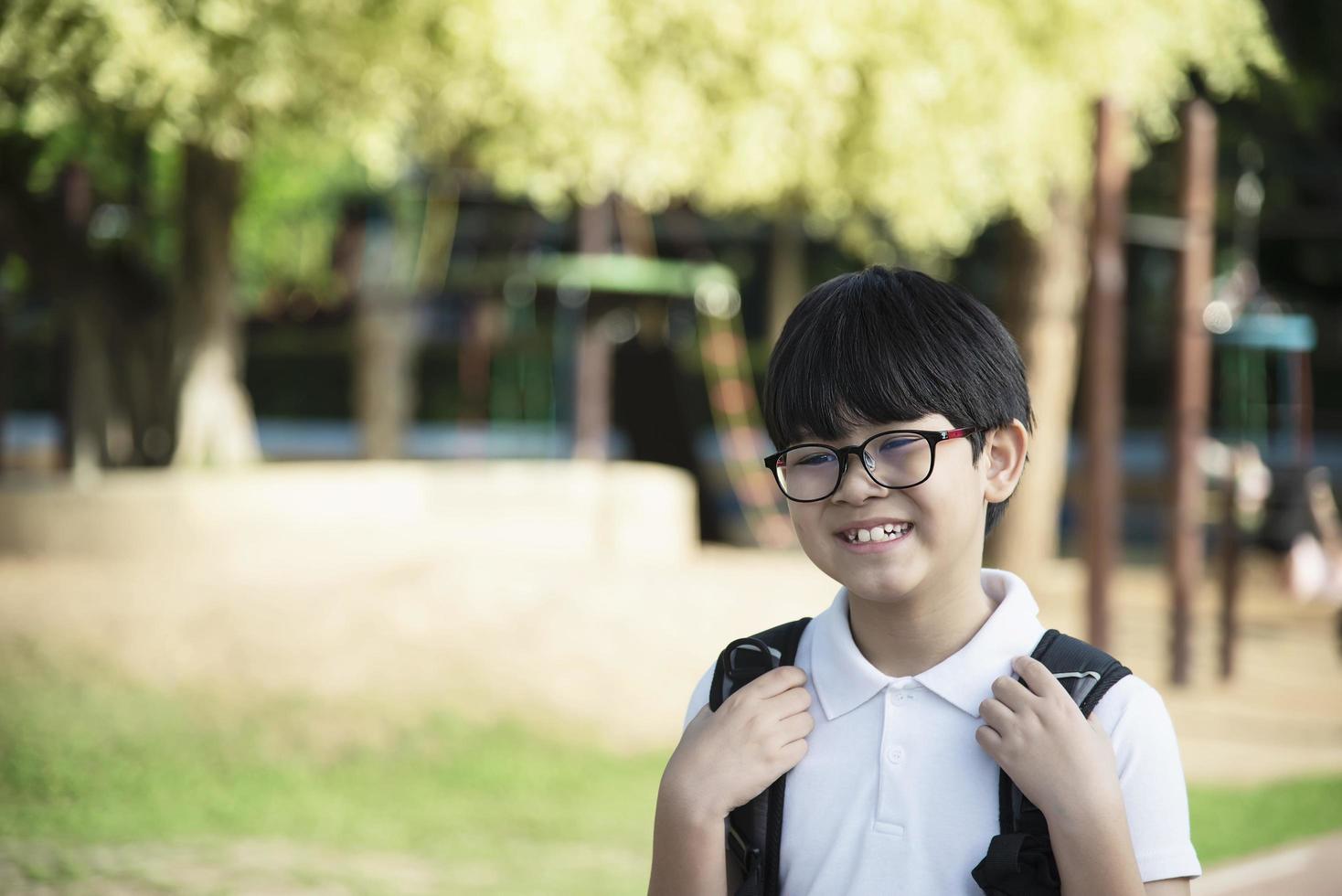 junger asiatischer thailändischer junge, der gerne zur schule geht - kinder zurück zum schulkonzept. foto