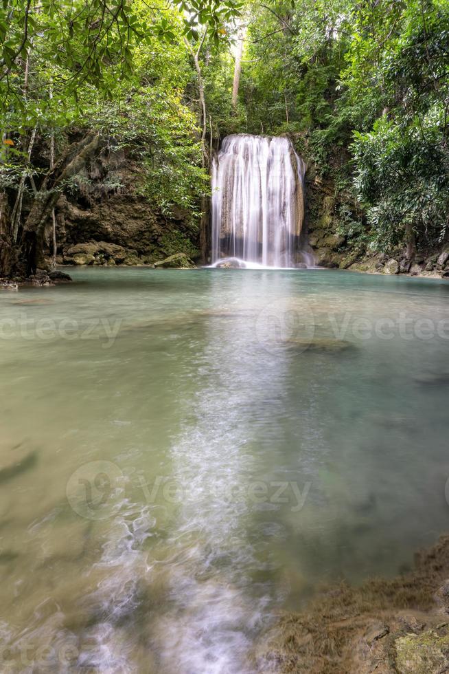 sauberes grünes smaragdwasser vom wasserfall umgeben von kleinen bäumen - große bäume, grüne farbe, erawan-wasserfall, provinz kanchanaburi, thailand foto