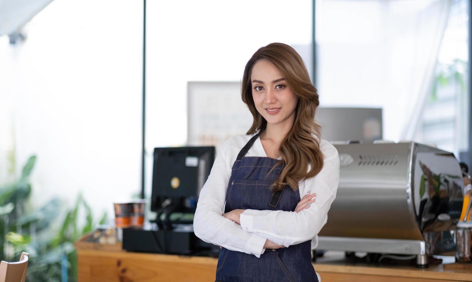 Startup erfolgreicher Kleinunternehmer SME Schönheitsmädchen steht mit Tablet-Smartphone im Café-Restaurant. Porträt der Barista-Café-Besitzerin mit asiatischer Bräune. KMU-Unternehmer-Verkäufer-Geschäftskonzept foto