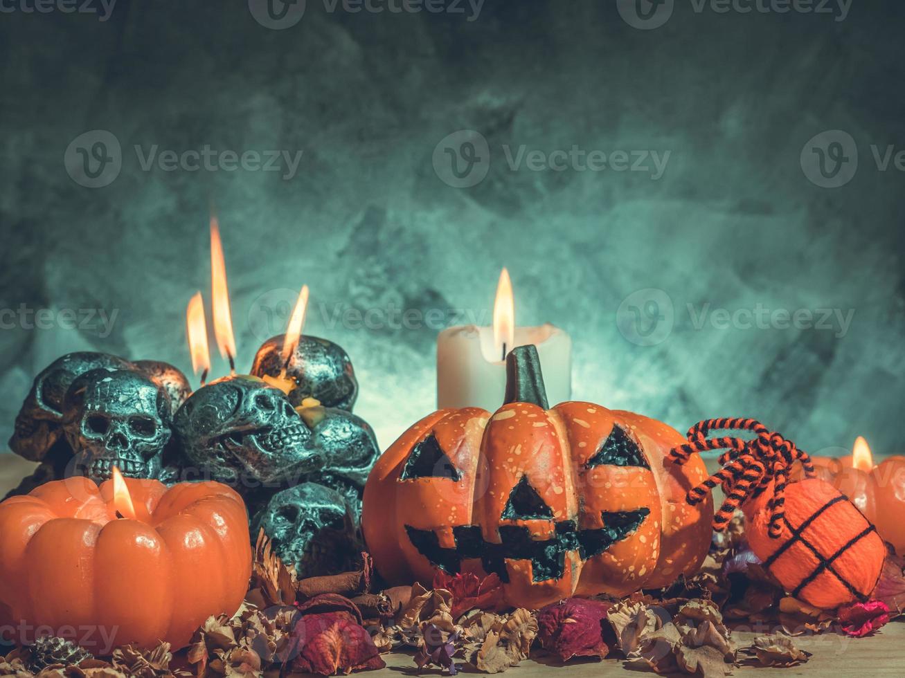 Halloween-Kürbisse mit Kerzenlicht und Totenköpfen auf dunklem Hintergrund. Vintage-Ton foto