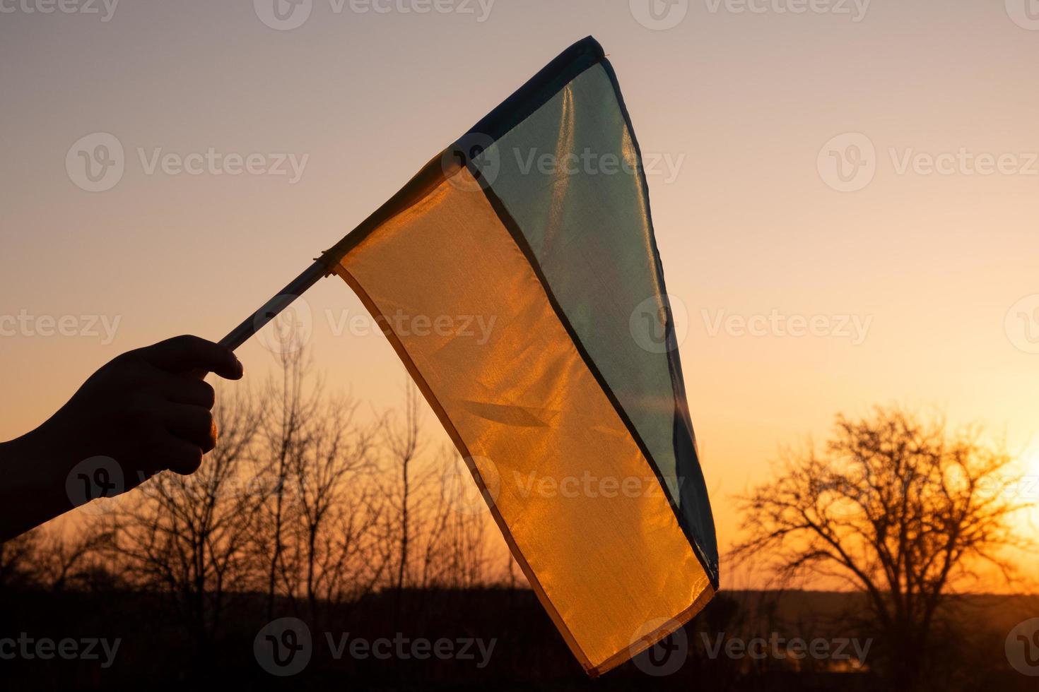 Flagge der Ukraine vor dem Hintergrund des Sonnenunterganghimmels foto