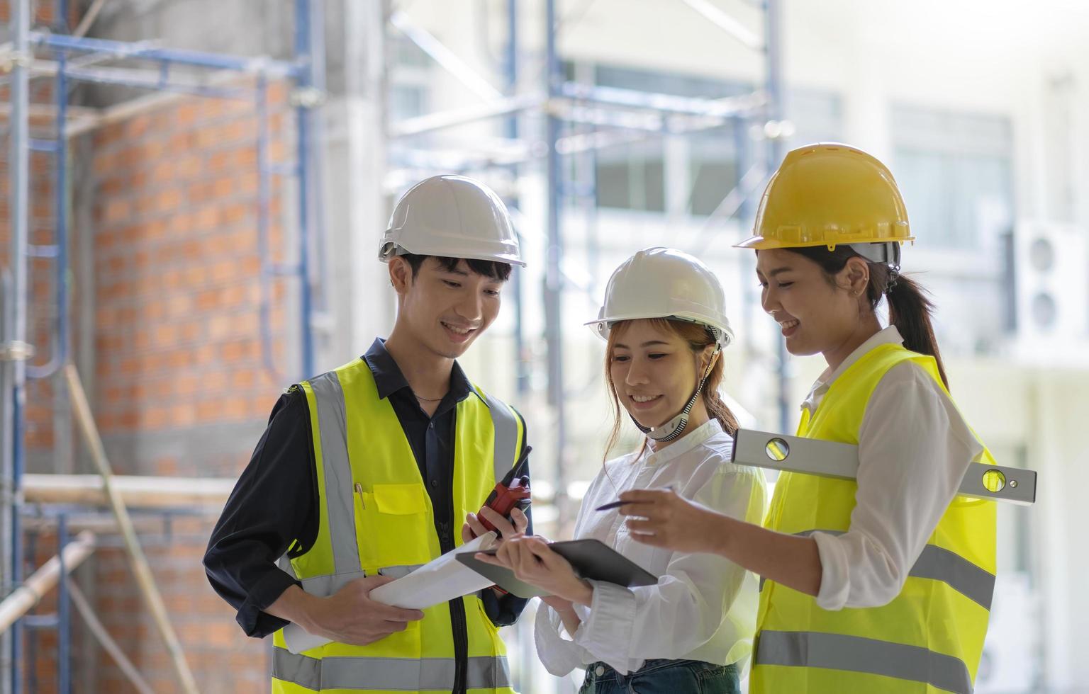 professionelles bau- und ingenieurteam, das am arbeitsplatz arbeitet. professioneller schwarzer architekt und bauarbeiter, der sich vor ort den bauplan ansieht. foto