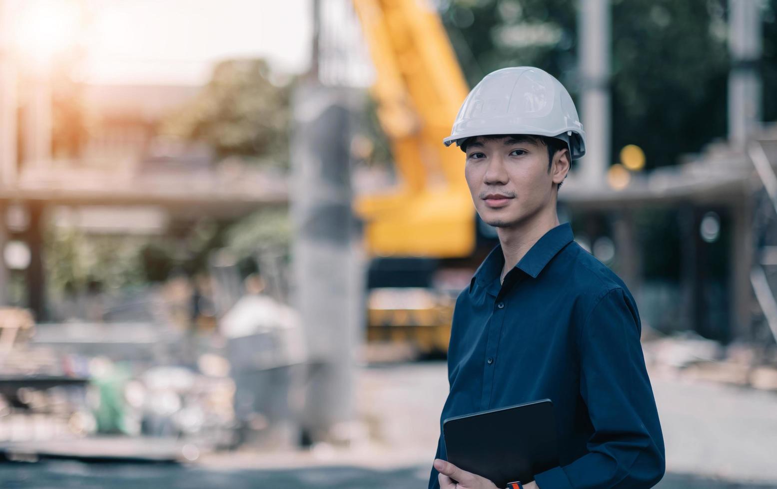 Der gutaussehende männliche Vorarbeiter mit Helm steuert und wartet das Betriebsprojektsystem. foto