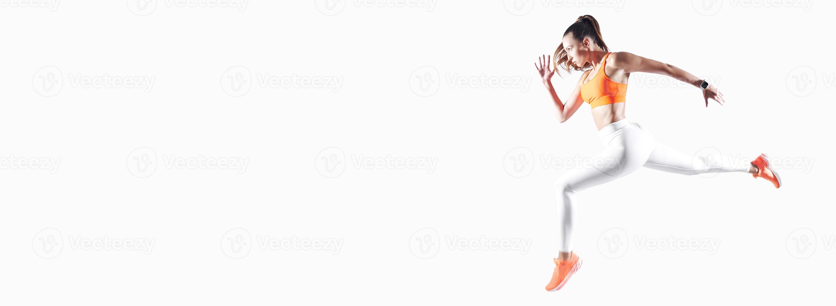 Selbstbewusste junge Frau in Sportkleidung, die vor weißem Hintergrund läuft foto