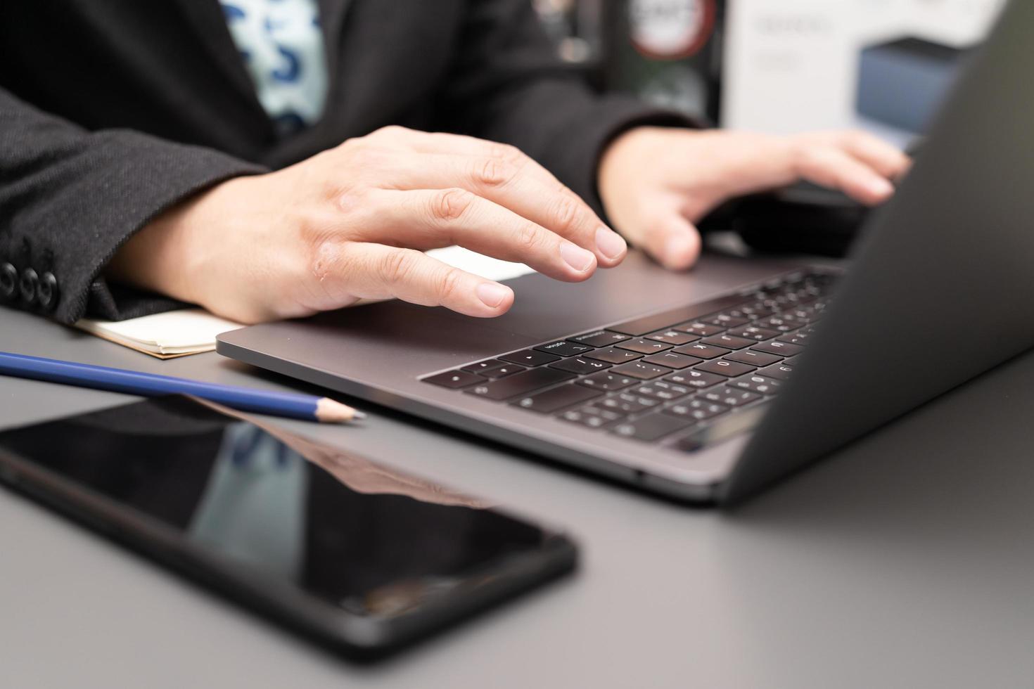 Organisation des Arbeitsprozesses in einem eigenen Notizblock. Genießen Sie leckeren Cappuccino, der drinnen am Laptop-Computer sitzt. Arbeiten am Schreibtisch mit Laptop und Smartphone. foto