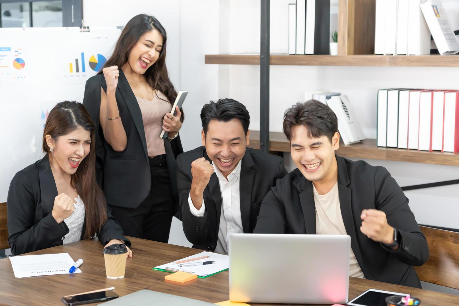 Glückliche Geschäftsleute am Computer feiern den Erfolg bei der Arbeit im modernen Büro. erfolgreiche Verhandlungen. geschäftsteam, das auf den computermonitor schaut. foto