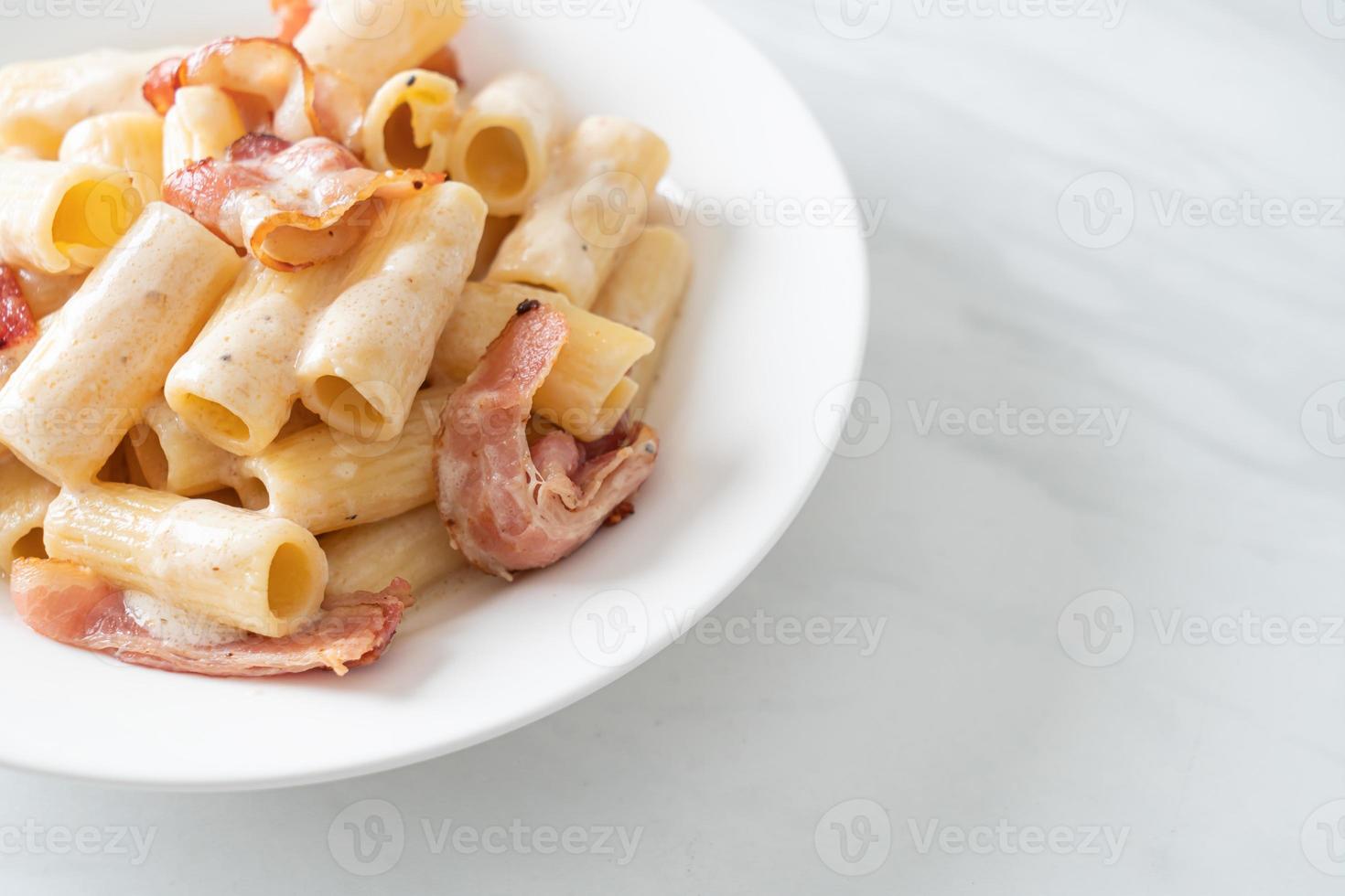 Spaghetti-Rigatoni-Nudeln mit weißer Soße und Speck foto