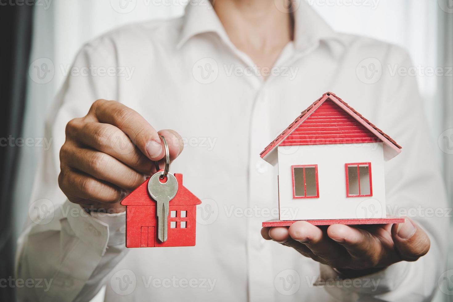 immobilienmakler bieten handhaltehausmodell mit schlüssel für kunden an und kaufen oder verkaufen haus. hypothekendarlehensgenehmigung wohnungsbaudarlehens- und versicherungskonzept. Platz kopieren foto