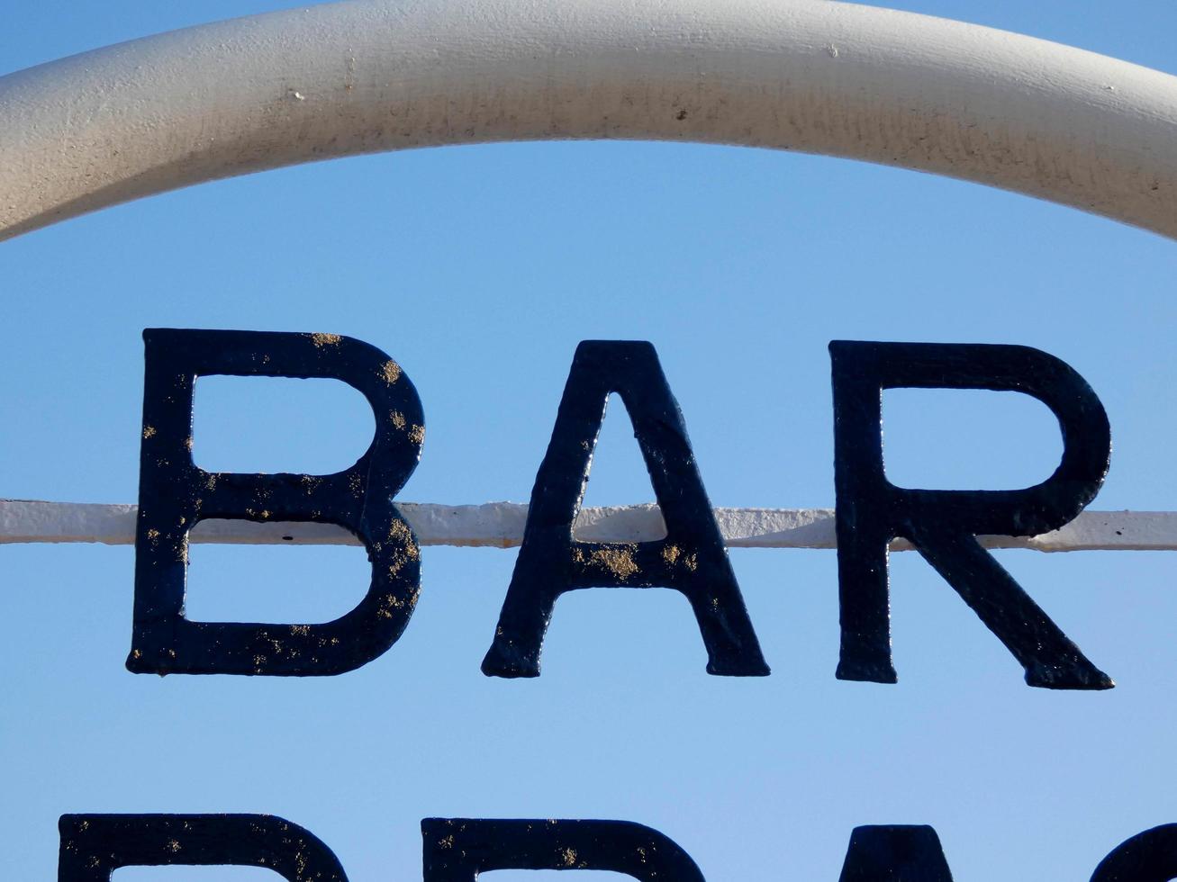 barschild, terrasse an der tür einer bar am strand foto