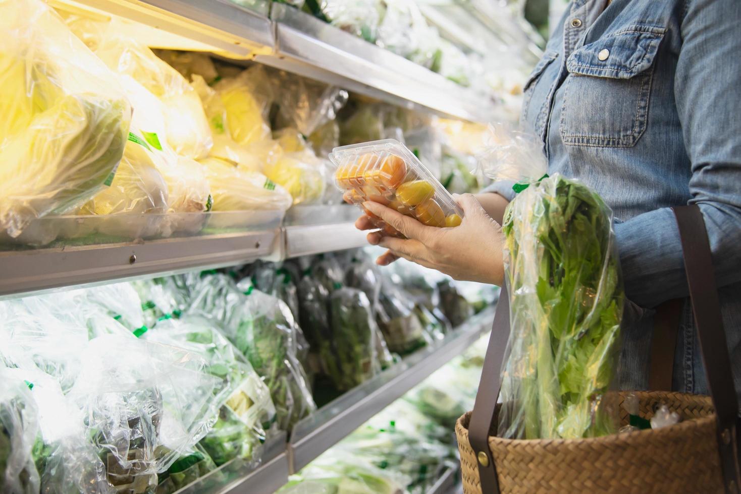 dame kauft frisches gemüse im supermarkt ein - frau im frischmarkt-lifestyle-konzept foto