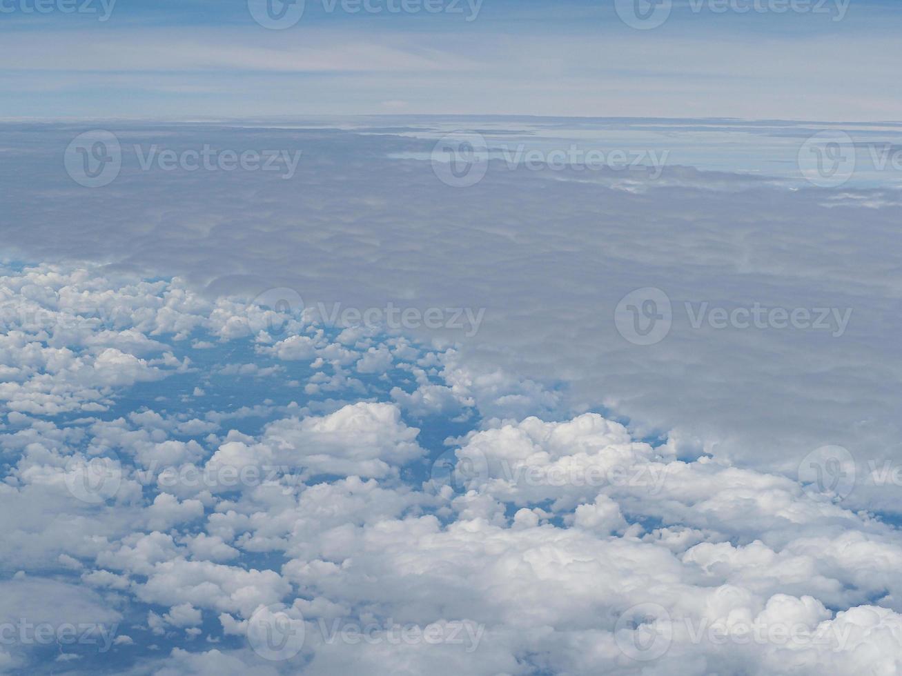 Luftaufnahme der Wolkenlandschaft durch das Flugzeugfenster gesehen foto