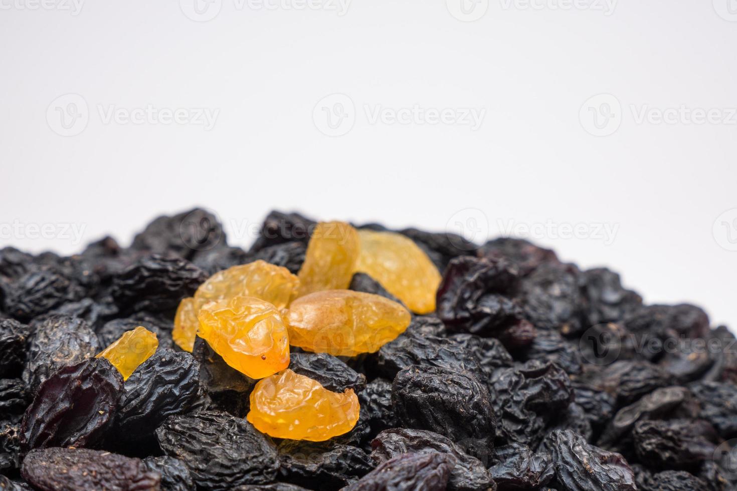 dunkle Rosinen mit einzelnen goldenen Rosinen als Hintergrund. vegetarischer gesunder süßer Snack. Bio-Lebensmittel. pflanzliche Ernährung. hochwertiges Foto