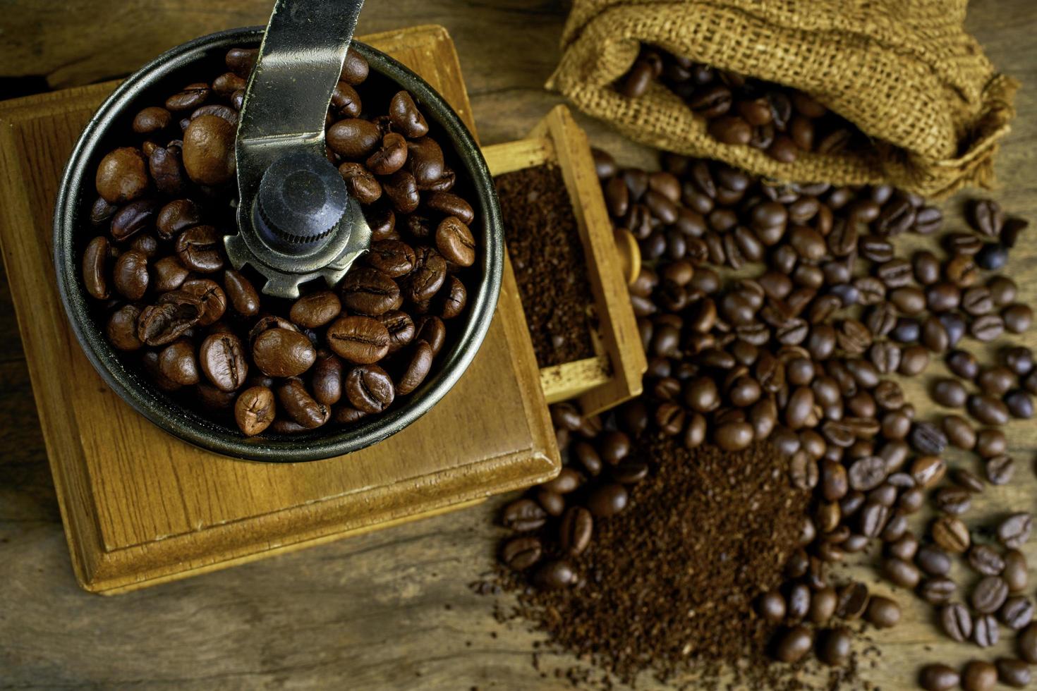 vintage kaffeemühle. alte retro handbetriebene kaffeemühle aus holz und metall. manuelle kaffeemühle zum mahlen von kaffeebohnen. auf dem alten hölzernen background.soft-Fokus. foto