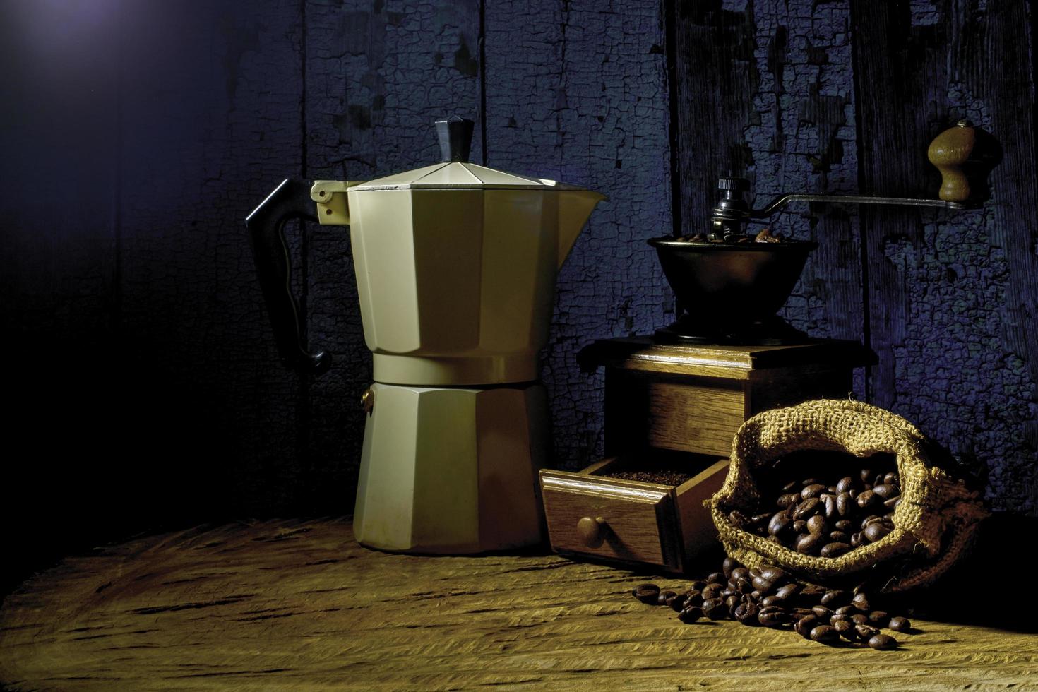 kaffeeset mit moka-kanne und mühle auf dem alten holzboden. Weicher Fokus. foto