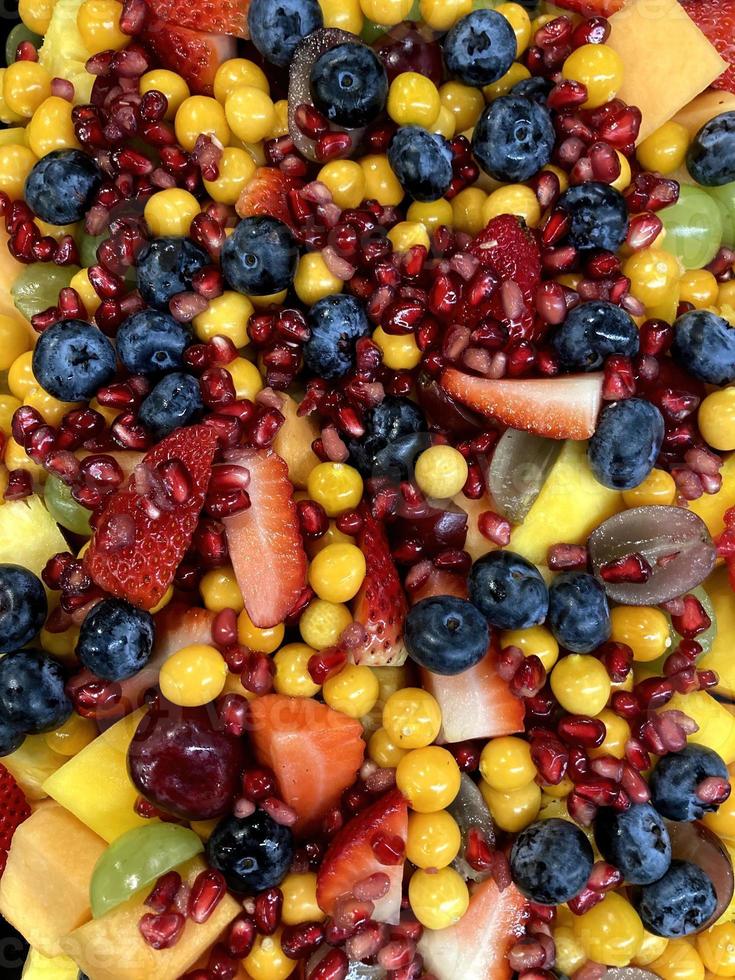 Ein Nahaufnahmefoto eines Obstsalats mit Früchten wie Erdbeeren, Blaubeeren, Granatäpfeln, Trauben, süßer Melone und Stachelbeeren, der sehr lecker aussieht foto