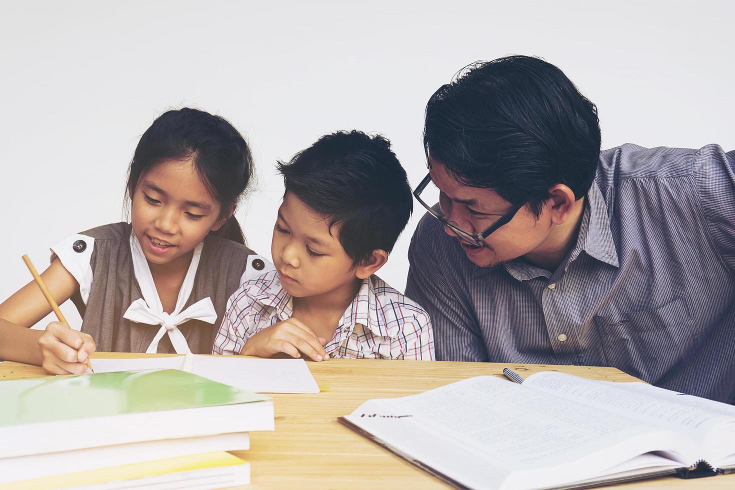 Papa unterrichtet seine Kinder bei den Hausaufgaben foto