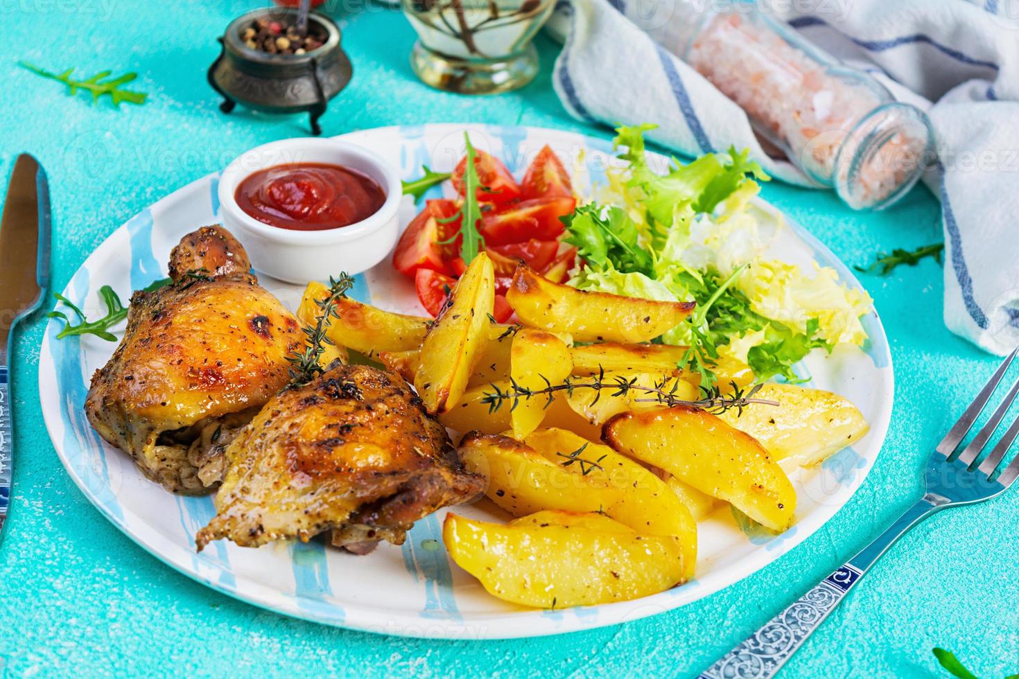 köstliches gebackenes Hähnchen mit Kartoffeln auf blauem Hintergrund foto