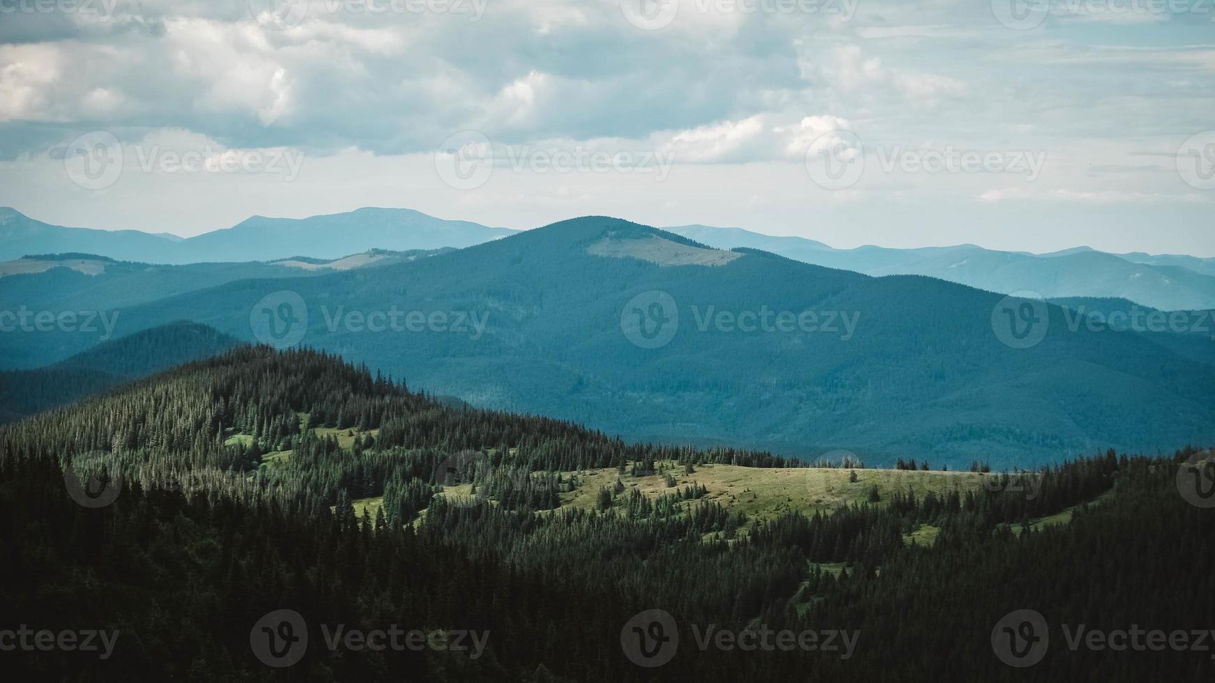 Grüne Berge von Karpaten mitten im Wald vor dem Hintergrund eines dramatischen Himmels foto